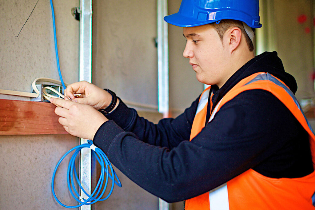 Casual trade assistant carrying out installation work on a construction site